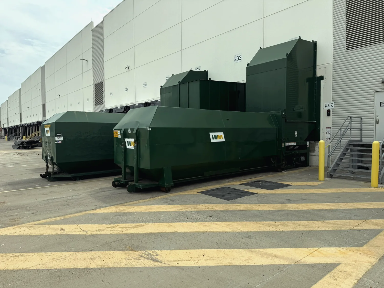Auger compactor with enclosure at a loading dock