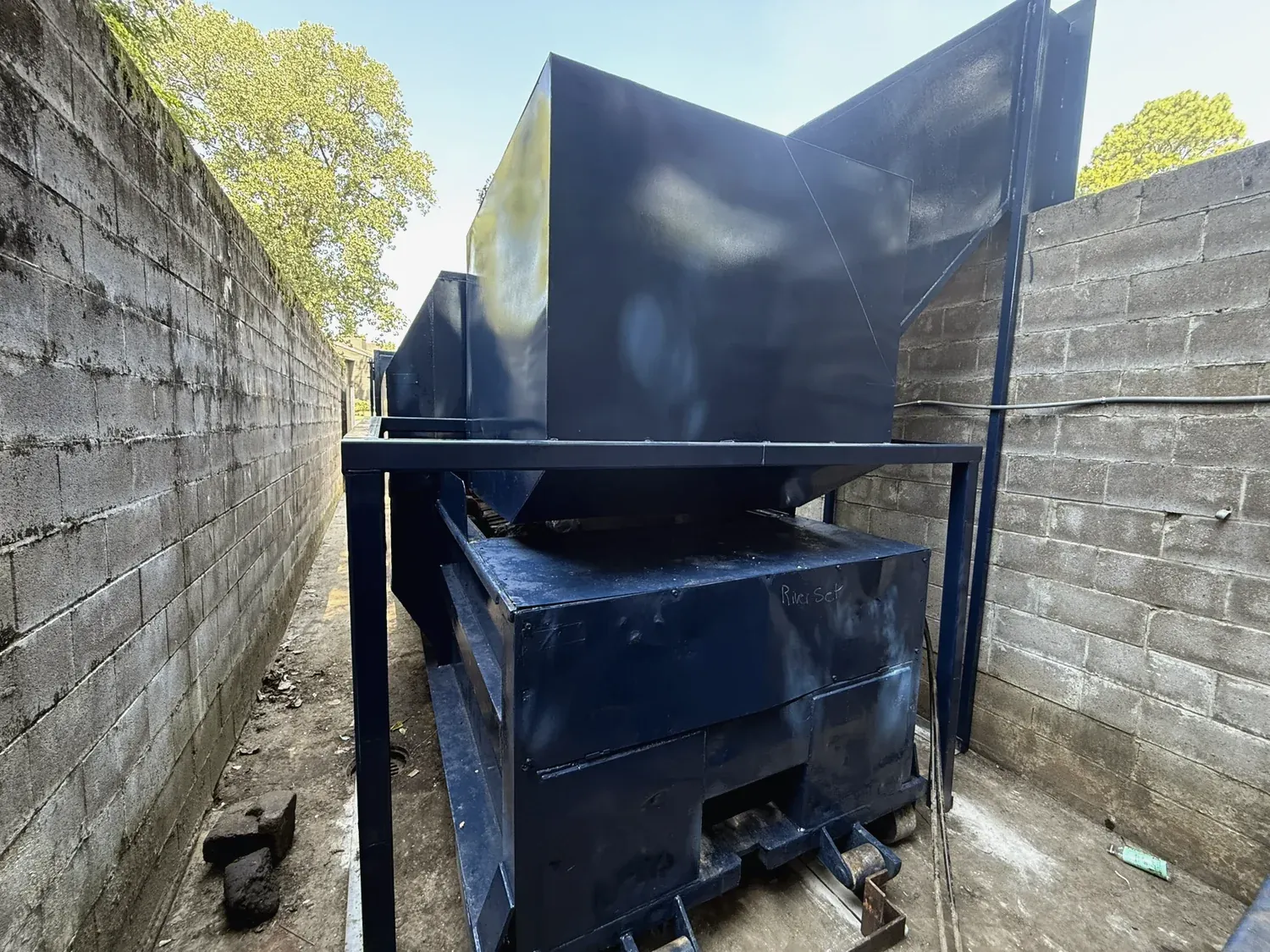 A fabricated feed chute and doghouse on a customer wall