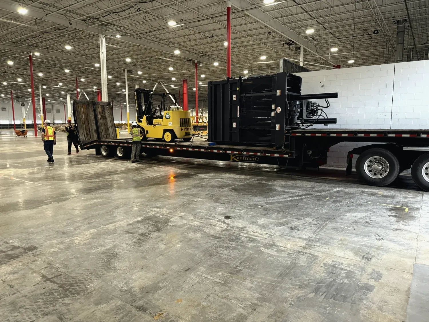 A Norton crew loading machinery onto a flatbed