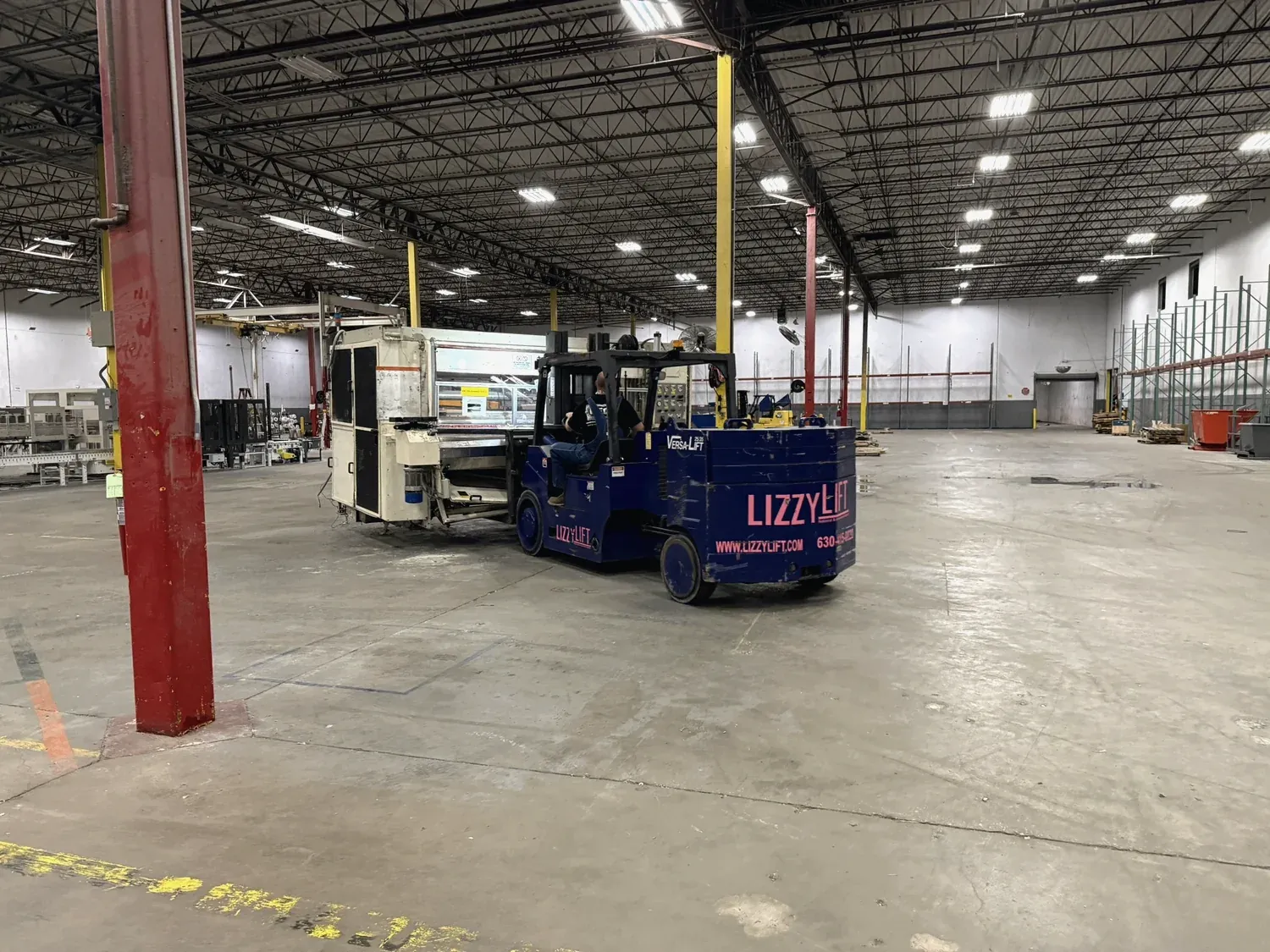 A Norton forklift carrying machinery through a plant