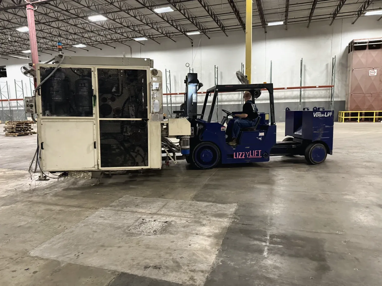 A Norton forklift moving heavy machinery